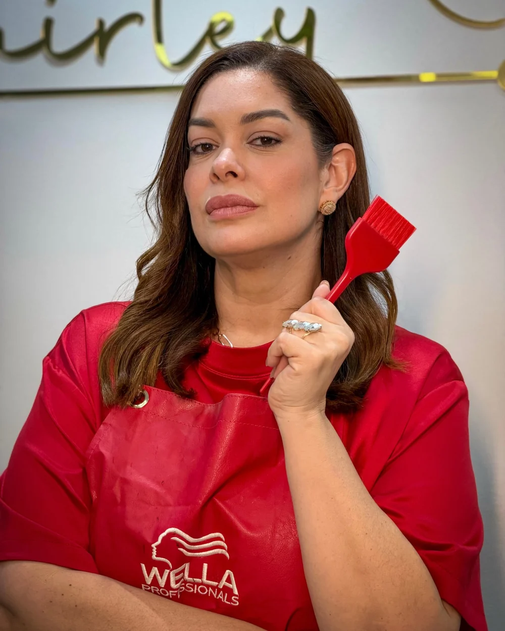 Shirley Diniz com avental vermelho e pincel de coloração